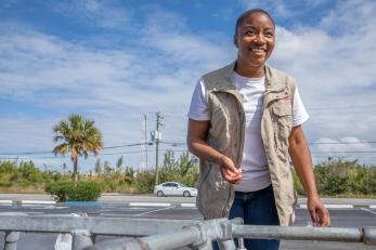 A person smiles while walking towards the camera in freeport, bahamas.