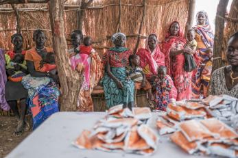 People waiting for food at a displacement camp.