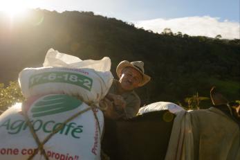 Man in colombia unloading a bag of farming supplies