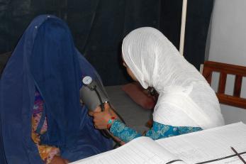 A midwife checks a woman's blood pressure
