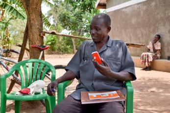 A ugandan farmer holding a mobile phone