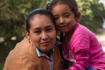 A woman and her daughter smiling at the camera