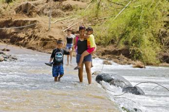 Family crossing a shallow stream on foot