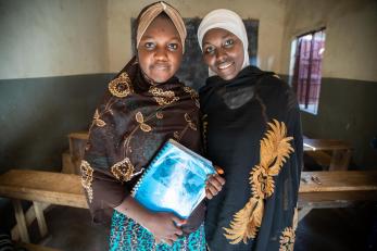 Two women stand in a classroom in nigeria