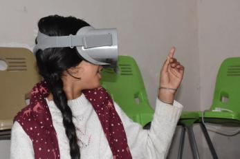 A young girl experiences meditation content through a virtual reality device in iraq.