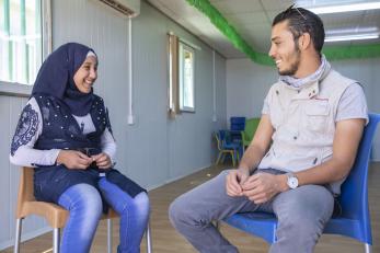A mercy corps program manager talks with an eight year old in zaatari, jordan, in july 2018.