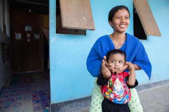 Wani and her son in front of their temporary home in indonesia