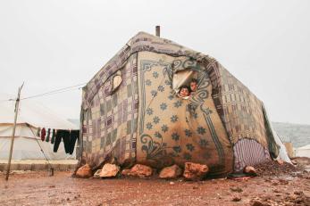 Two children look out the small window of their family’s tent, after a huge rainstorm hit al-rayyan camp in the area northwest of idlib.