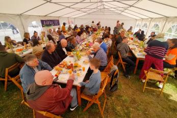 People displaced by conflict sitting at communal dinner tables.