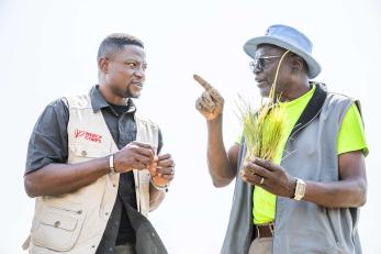 A communications manager for mercy corps’ rural resilience activity program speaks with the owner of a farm.