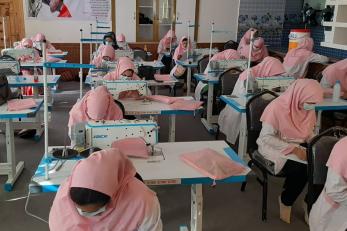 Women use industrial sewing machines in a training course