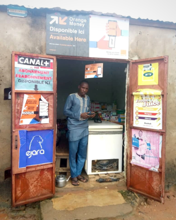 A person standing in a doorway holding a mobile device.