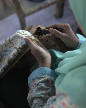 A person performing a batik making tradition.