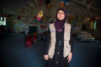 A woman standing in a building in a refugee camp
