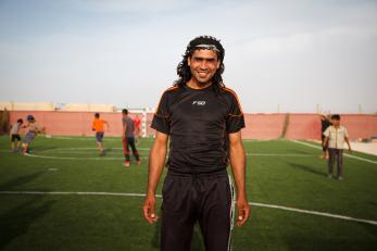 A man stands on a soccer field outside