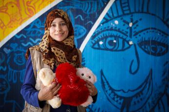 A young woman holding stuffed bears and a stuffed red heart