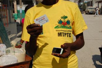 man holding mobile phone and cash card