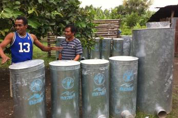 Mario de Jesus (at left, in blue shirt) and other local blacksmiths are benefitting from Mercy Corps' SECURE program by building silos for sale to neighboring farmers. Photo: Wahyu Nugroho/Mercy Corps