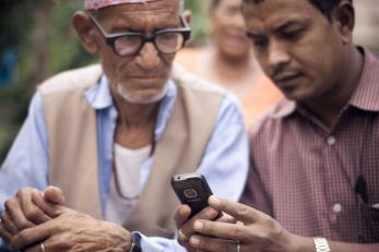 two men looking at a mobile device