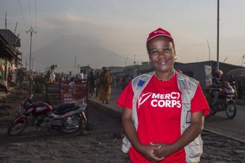 The DRC Director of Communications Odette poses for a picture in front of Mount Nyiragongo volcano.