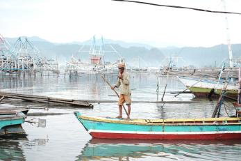 A man riding his boat in coastal neighborhood in Pulau Pasaran Bandar Lampung, Indonesia.