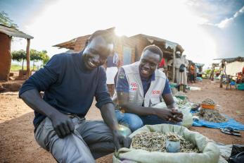 A Project Officer for Mercy Corps, talks to Festo James, a South Sudanese refugee and beneficiary of the DREAMS Program.