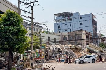 Urban scene, with destroyed building in background.