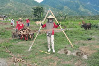 Women work together on a farming resilience project outdoors in agricultural setting.