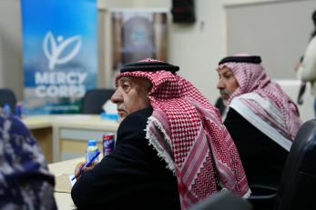 Men listening to a speaker at a conference.