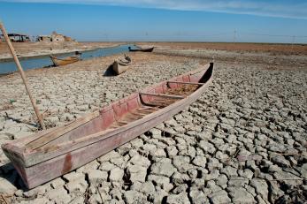 A abandoned boat on dry marshland during a drought in Southern Iraq.