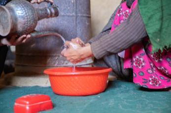 Washing hands in a basin.