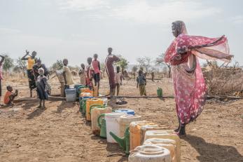 Women gather at a water pump in Thobo camp, where tens of thousands of people displaced by the war in Sudan are now living.
