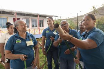 In San Andrés, participants perform a hands-on fire response drill in an emergency preparedness workshop to strengthen community resilience for future disasters. 