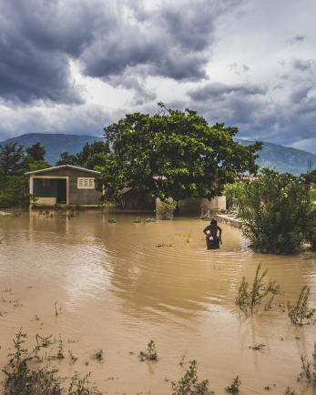 flooded open area in Haiti with a person standing off to the right in the water