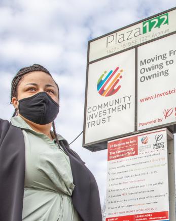 A person standing outside a neighborhood commercial-retail space. 