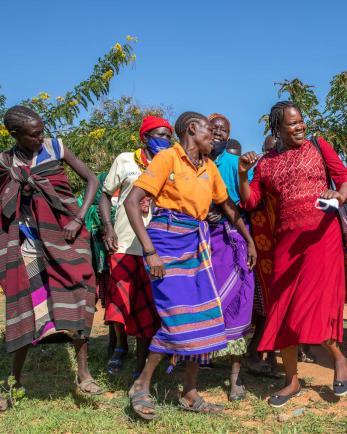 Ugandan community members dance.