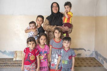 Faiza (center) with her grandchildren and nephews. Faiza’s home was destroyed and her car burned. There is nothing left there, she says. Emergency cash has helped Faiza ensure her family's needs are met in the temporary home they share with five other groups.