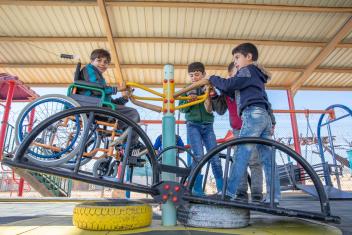 Yousef, left, plays at an inclusive playground at Zaatari refugee camp in Jordan. Mercy Corps’ inclusive education program supports schools at the camp, which houses the largest population of Syrian refugees.