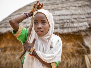 Child in niger wearing colorful bracelets and a scarf