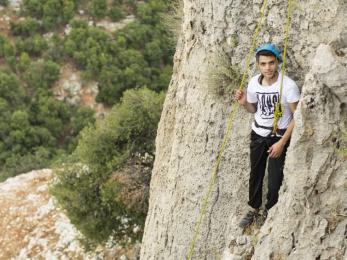 Mohammad khaldoun takes a short rest before completing the climb. mercy corps staff take syrian refugee youth rock climbing, among other wilderness therapy activities. all photos isidro serrano selva for mercy corps.
