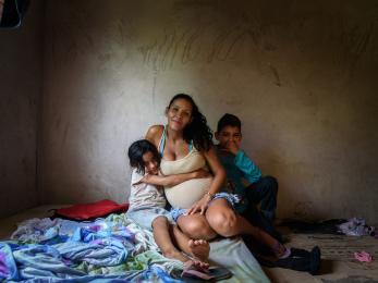 Woman with two children sitting on floor with blankets