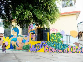 A mural at a school reading "unidas construimos comunidad"