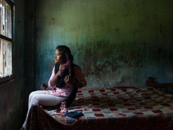Teen girl in india sitting on her bed and brushing her hair