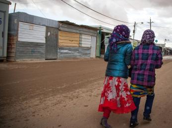 Image: two girls walking from behind in za'atari camp for syrian refugees