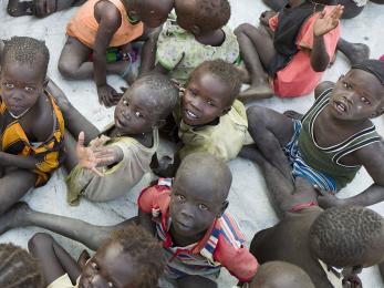 A group of children experiencing famine sitting in a group