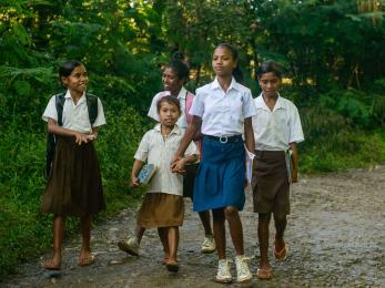 Lourdes walks to school in the company of younger classmates in timor leste