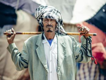 A portrait of a pastoral beneficiary holding a stick in kebribeyah, ethiopia.