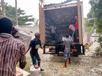 People unloading supplies from a truck.