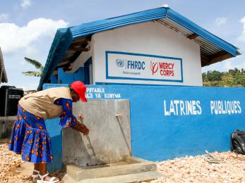 A Congolese woman at a water point and latrine in North Kivu to strengthen hygiene and prevention.