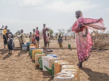 Women gather at a water pump in Thobo camp, where tens of thousands of people displaced by the war in Sudan are now living.